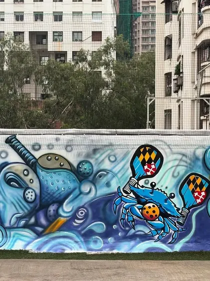 A section of the pickleball mural, showing the playful mix of sports equipment and sea creatures in a vibrant, wavy composition.