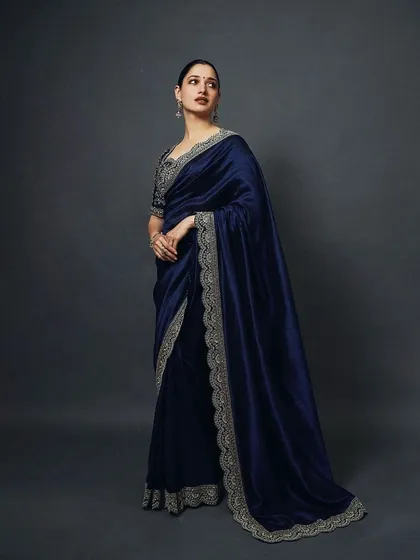 A stunning navy blue saree with a heavily embroidered border, as seen on the beautiful Tamannaah Bhatia. This look is the epitome of classic elegance.