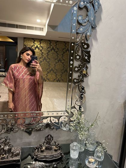 A mirror selfie in a pink striped kaftan. Kaftans are my go-to for comfortable festive dressing at home.