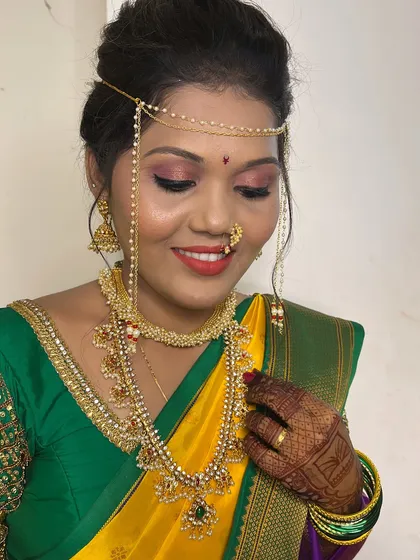 A close-up of the bridal makeup, featuring bold red lips and shimmery pink eyeshadow that perfectly complements her attire.
