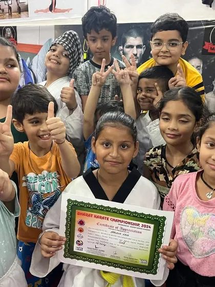 A student proudly displays her certificate of appreciation from the Bharat Karate Championship, surrounded by her supportive teammates.