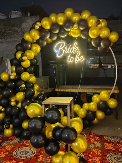 A close-up of the 'Bride to be' photo backdrop. This one features a black and gold balloon ring with a neon sign, perfect for taking pictures.