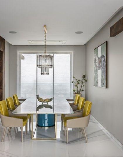 Dining at new heights. In this 4000 sq. ft. Mumbai penthouse, the dining area is a destination with panoramic city views. The bespoke dining table and pops of yellow create an ambiance of pure luxury.