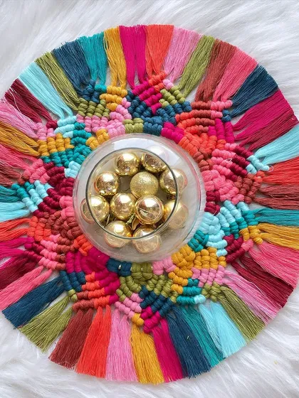 This colorful piece is a modern take on a traditional art form. It's a reusable macrame rangoli that can be used as a festive centerpiece for Diwali or hung on the wall as a vibrant decoration year-round.