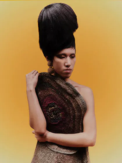 An avant-garde look where the large, sculptural earrings are a key part of the overall styling. The dramatic hair and makeup complement the artistic nature of the jewelry.