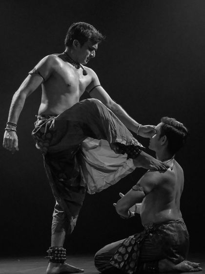 A dramatic black and white still from 'ATAH'. This image captures the intensity and physical dialogue between the two dancers in this duet production.