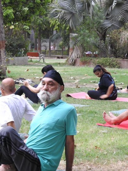 Yoga is for all ages and all walks of life. This candid shot from our outdoor class captures a moment of rest and reflection.