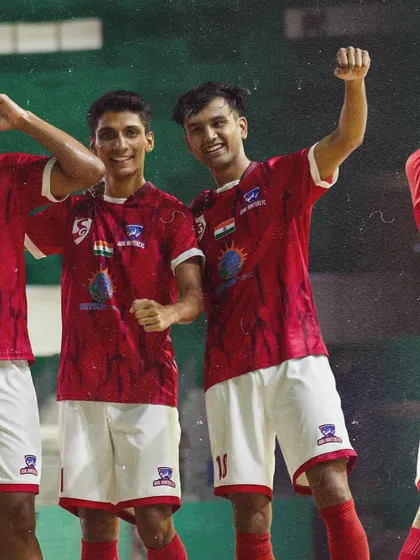 Two players celebrating with fists pumped, sharing the excitement of a goal.