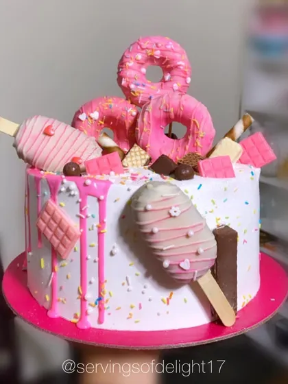 For those who love a bit of everything, I create these fun "overload" cakes. This design is topped with donuts, cakesicles, and all sorts of sweet treats, making it a whimsical and delicious choice for any party.