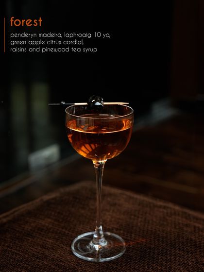 Our Forest cocktail, a sophisticated blend of Penderyn Madeira whisky and Laphroaig 10-year. The smoky peat is balanced by a green apple citrus cordial and pinewood tea syrup, creating a deep, earthy, and complex drink.