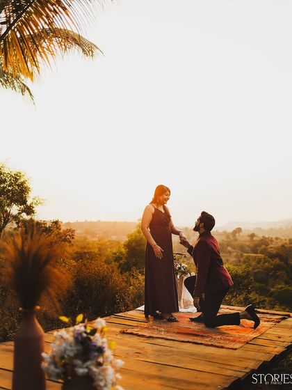 A classic proposal during the golden hour. He gets down on one knee on a scenic wooden deck overlooking a valley, creating the perfect romantic setting to ask the big question.