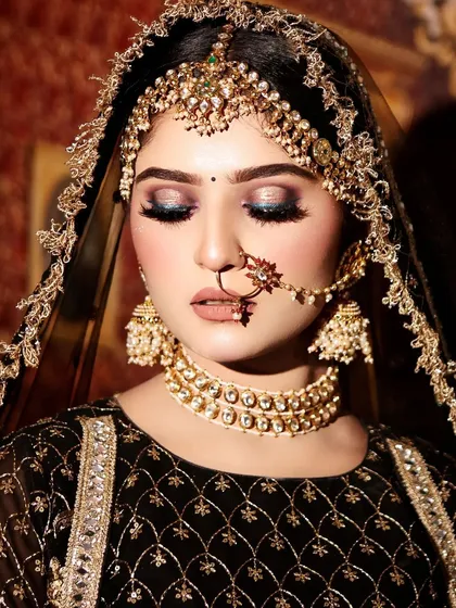 A close-up on the stunning makeup and jewellery paired with the black bridal lehenga. The smokey eyes and choker necklace create a dramatic and modern bridal look.