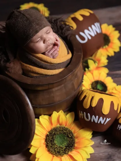 A sweet-as-honey theme for your little cub. This 'Winnie the Pooh' inspired newborn shoot features a baby nestled in a 'hunny' pot, surrounded by sunflowers for a warm and cheerful photo.