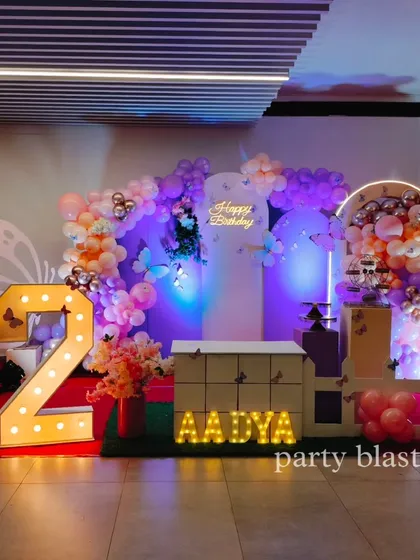 A light-up number '2' adds a personalized focal point to this butterfly party, surrounded by beautiful balloon clouds and butterfly accents.