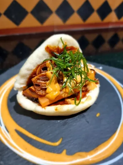 A beautifully plated Korean-style bao, showing the delicious filling and sauce. Our baos are a popular choice for parties, offering a modern and tasty handheld bite.