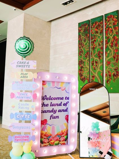 A light up welcome sign and a directional post for a "Two Sweet" second birthday party, guiding guests to the different fun zones.