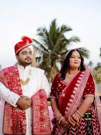 A portrait of the couple on their wedding day, with palm trees in the background giving it a destination wedding feel.
