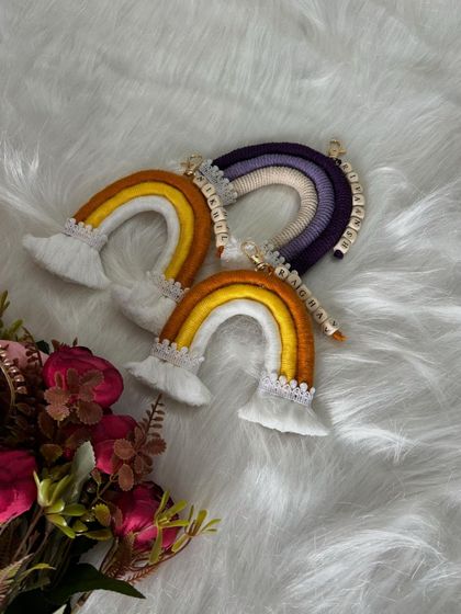 Another view of the rainbow keychains, showing their fluffy clouds and delicate lace trim.