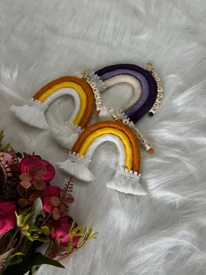 Another angle of the personalized rainbow keychains, showing the detail of the lace trim and the wooden name beads.