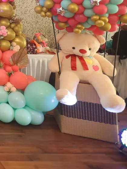 Welcome to the cutest celebration! For a 'We Can Bearly Wait' baby shower, we designed this adorable hot air balloon prop with a giant teddy bear, creating a whimsical and heartwarming centerpiece that guests loved.