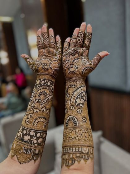A stunning full-arm design with large, bold mandalas and paisley motifs, showcasing a rich and traditional bridal style.
