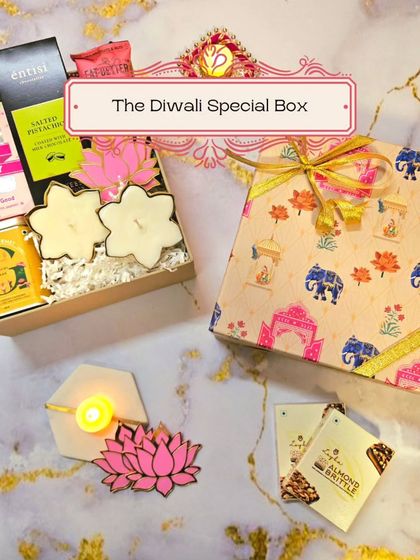 A beautiful flat-lay of The Diwali Special Box, showcasing the festive packaging and some of the contents like floral candles and lotus rangoli cutouts.
