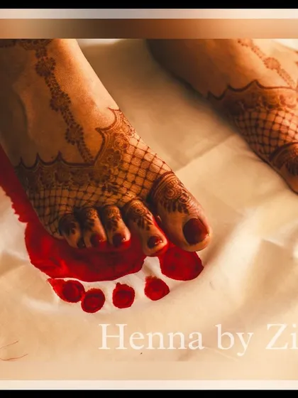 A traditional and emotional shot of the bride's feet during the alta ceremony, with her beautiful mehendi peeking through.