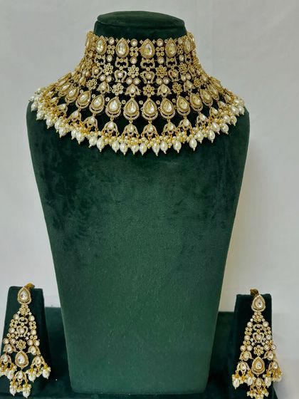 This rental set features a delicate Kundan and pearl choker with matching drop earrings. It is perfect for sangeet or engagement ceremonies.