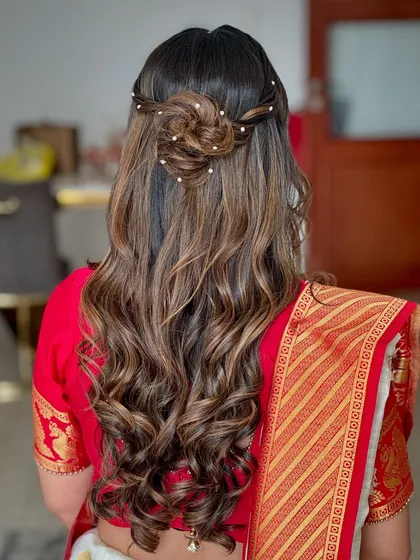 A detailed look at the beautiful floral half up-do we created for her godbharai. It adds a touch of tradition and elegance to her modern hairstyle.