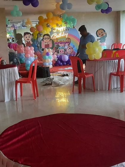 Setting up for a Cocomelon themed birthday party. This behind-the-scenes shot shows the balloon arrangements and character cutouts being placed.