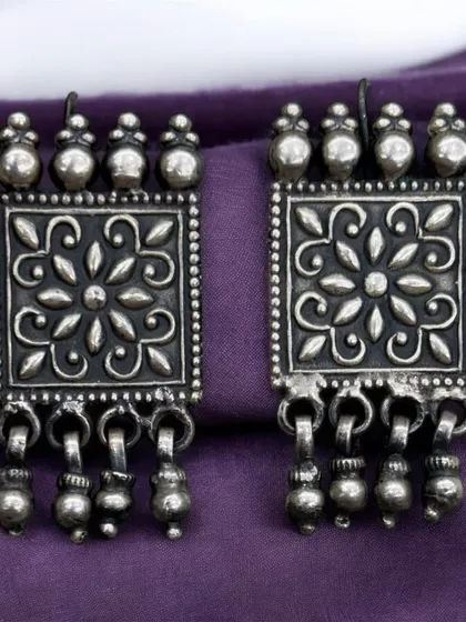 Another pair of elegant, rectangular oxidised silver earrings. These have a beautiful floral-stamped pattern and ghungroo drops.