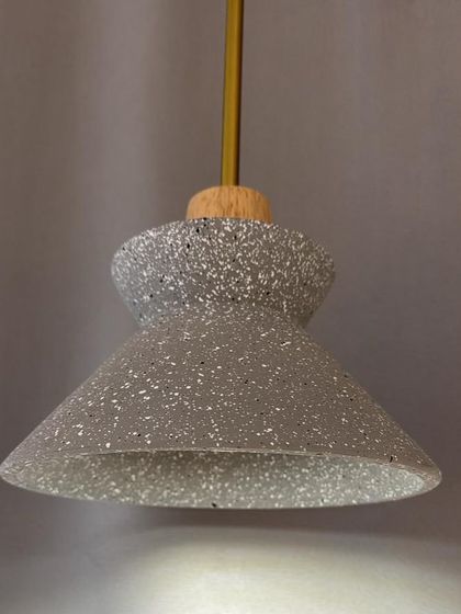 A pendant light with a terrazzo shade. The speckled pattern of the terrazzo adds a playful and modern touch.