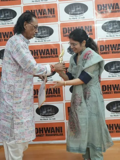 A moment of respect as a senior guru presents an award to an adult learner.