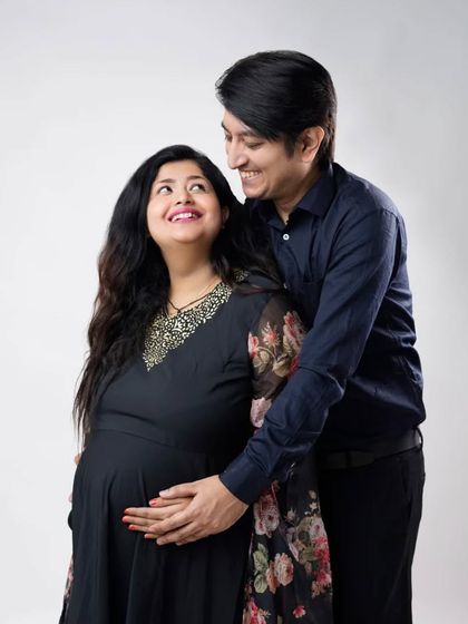 A look of pure love and adoration between partners. This simple, elegant studio portrait beautifully captures the emotional core of their relationship as they await their baby.