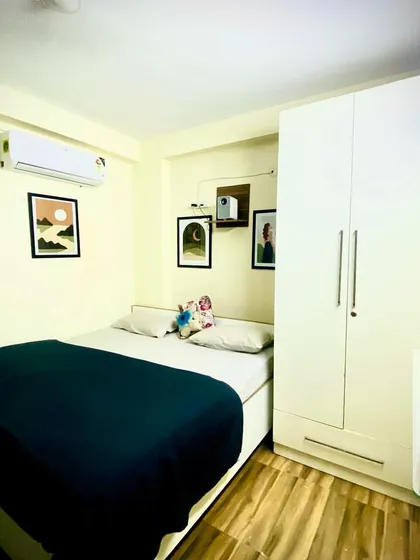 For a simpler stay, the bedroom is bright and clean during the day, with modern art, an AC, and a comfortable double bed.