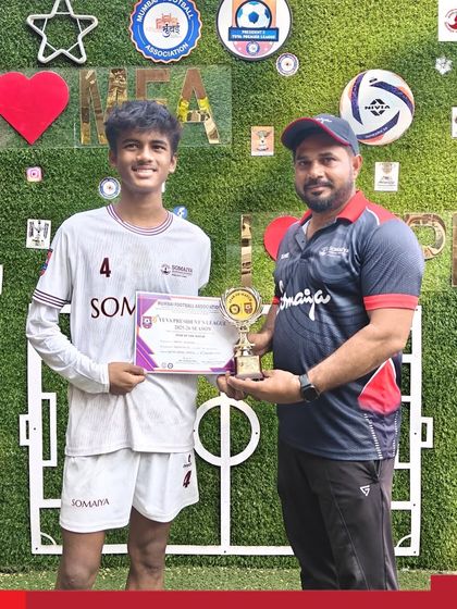Daksh, the Man of the Match, receives his trophy from a coach after scoring two goals for the Somaiya FC U-16 team.