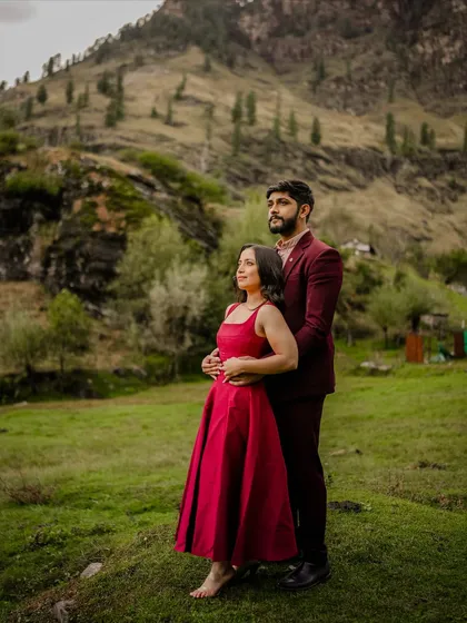 A classic pose with the couple looking towards their future, set against the green hills of Manali.