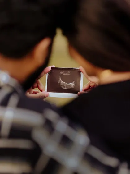 Sometimes the smallest things tell the biggest stories. This close up shot focuses on the couple holding their baby's first picture, the ultrasound scan. It is a powerful and emotional image that marks the real beginning of their new adventure.