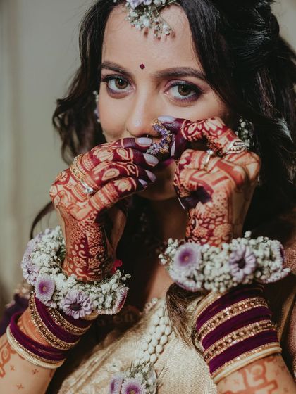 A close-up on the details: the beautiful henna and the fresh floral jewelry for the baby shower.