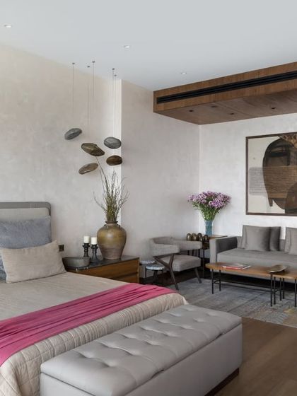 The master bedroom in the DLF Camellias apartment unfolds in two parts: a sleeping area and a sunlit sitting area. The space is layered with soft textures, bespoke furniture from our Koko collection, and art collected from across India, creating a luxurious and comfortable retreat.