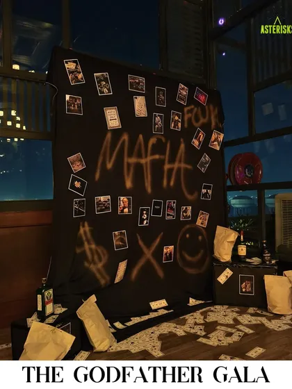 A "Godfather Gala" themed party photo booth. We created a moody, interactive backdrop with graffiti, scattered money, and polaroids for guests to take memorable, in-character photos.