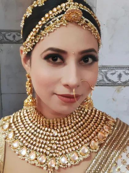 A bride wearing a heavy, uncut Polki necklace with a white and gold saree. This is an elegant and sophisticated look for a reception or engagement.