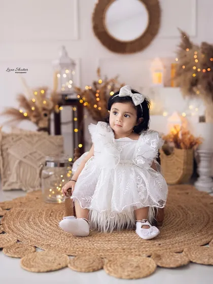 A beautiful portrait of a baby girl in a lacy white dress, part of our popular boho-themed first birthday session.