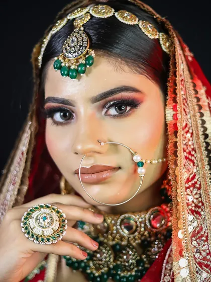 A close-up on the bride's face, highlighting the sharp winged eyeliner and the detailed nath.