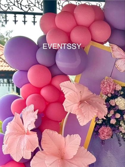 A detail shot of the balloon garland and oversized paper flowers. This close-up shows the texture and artistry of the handmade flowers that make the decor so unique.