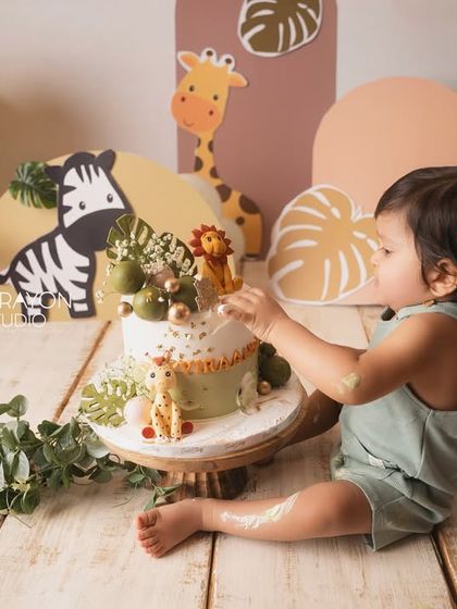 The cake smash begins. A tentative first touch of the frosting, a moment of curiosity before the messy fun starts.