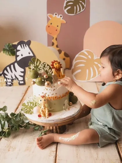 The cake smash begins. A tentative first touch of the frosting, a moment of curiosity before the messy fun starts.