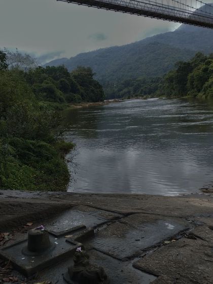 A serene shot of the river and a small shrine near the Netravathi trek base.