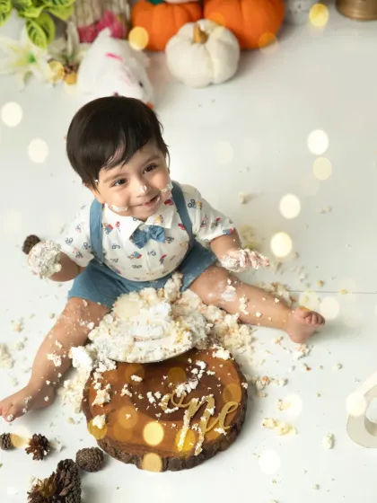 Pure joy and a face full of frosting. This overhead shot captures the fun and mess of a first birthday cakesmash in a beautifully styled holiday theme.