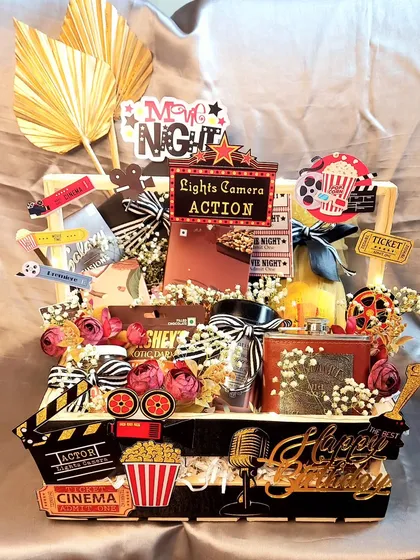 The ultimate movie night hamper. For the movie buff in your life, this basket is themed with cinema decor and packed with popcorn, drinks, and all the best snacks.